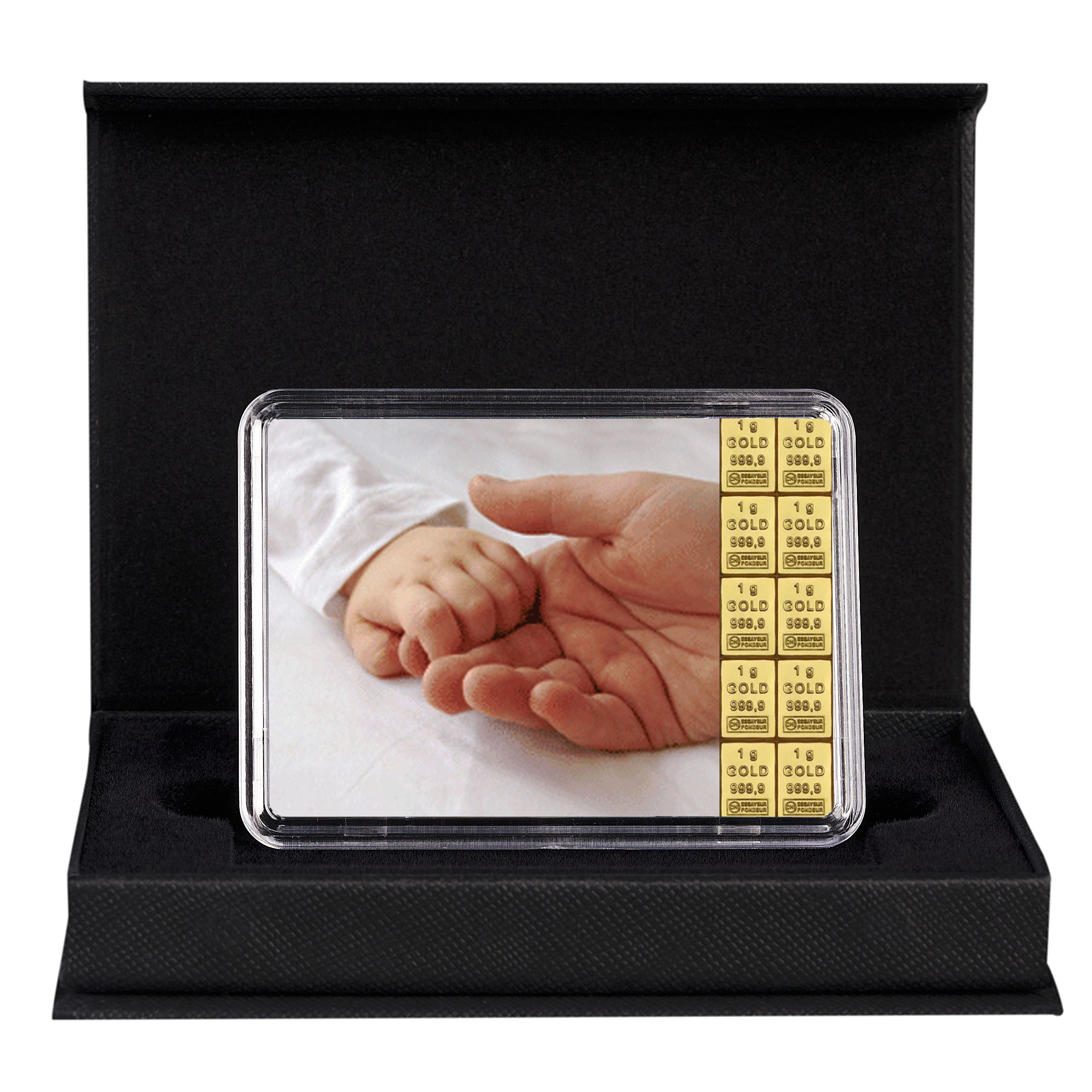 Schwarze Geschenkbox mit Etui, darin eine Goldtafel mit Motiv einer Babyhand in einer Erwachsenenhand und 10x 1g-Goldbarren – exklusives Geschenk zur Geburt.